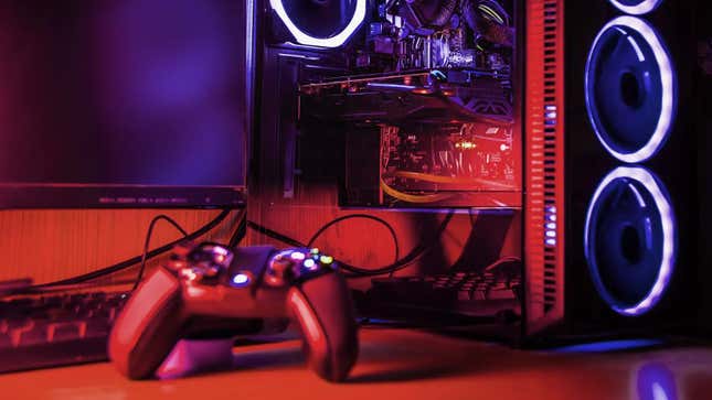 A gaming PC sits on a table in pink light. 